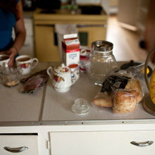 Food on a table as a woman stirs her coffee in a mug